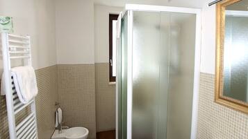 Ein Badezimmer mit Duschkabine, Waschbecken in Weiß und Toilette.