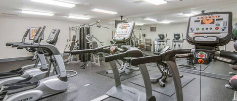 A gym with treadmills, elliptical machines, and weight equipment.