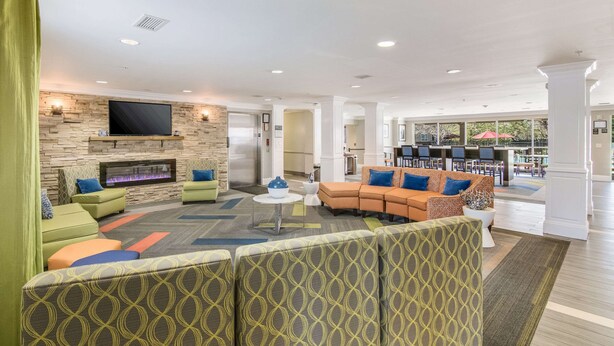 A spacious lobby with a fireplace, comfortable seating areas, and a large television. - Sleep Inn & Suites Columbus near Fort Benning (Columbus)