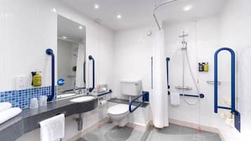 A modern bathroom with a sink, toilet, and shower area, equipped with grab bars and a shower curtain.