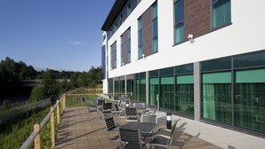 A modern building with a wooden deck, outdoor seating, and large windows. - Holiday Inn Express Hotel Burnley M65 JCT10 by IHG (Burnley)