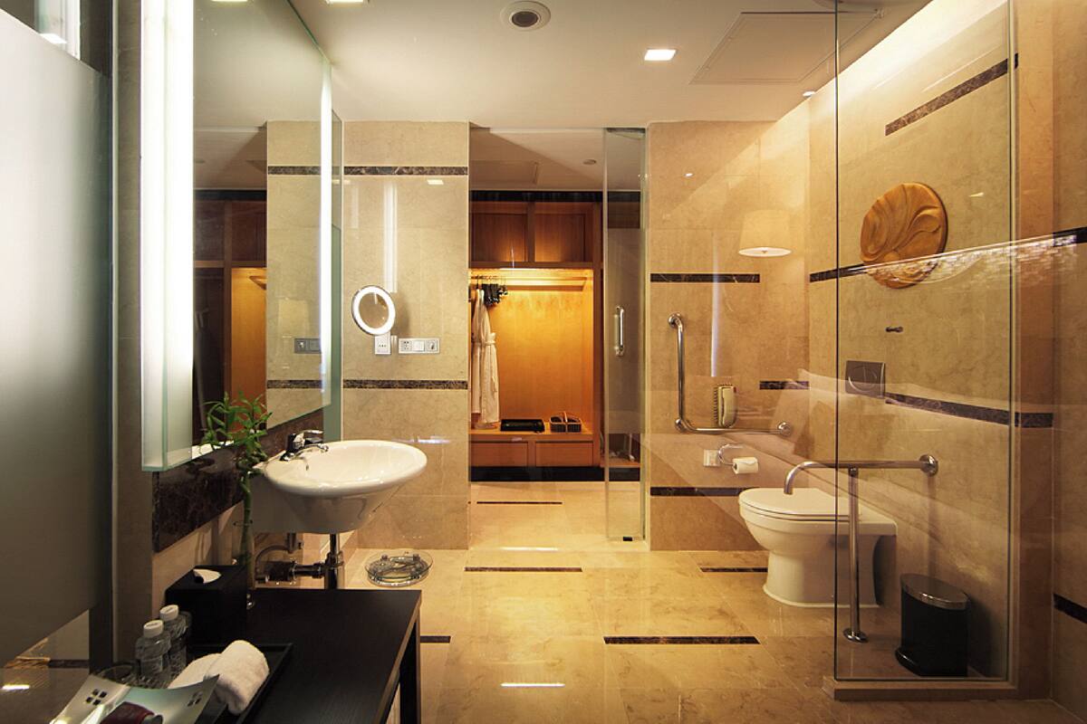 A modern bathroom with a glass-enclosed shower, a sink, and a toilet.