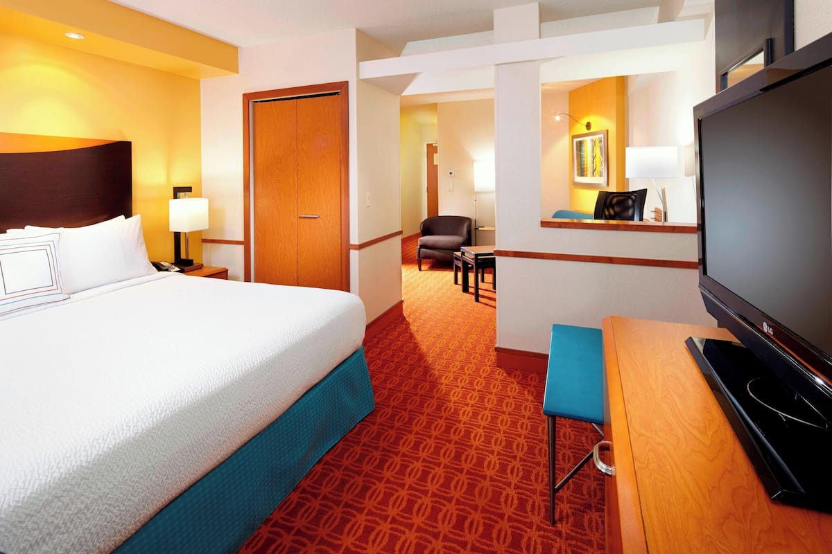 Une chambre d’hôtel avec un grand lit, une télévision, un bureau et une chaise.