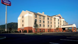 Un hotel Fairfield Inn & Suites by Marriott con un diseño moderno, entrada techada y estacionamiento.