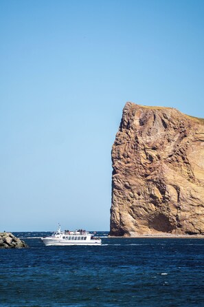 A boat near a large rock formation.