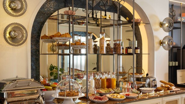 Un buffet proposant une variété de plats et de boissons, un miroir reflétant la pièce et une arche décorative.