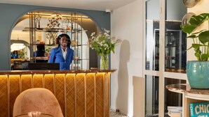 Un espace d’accueil au design moderne, comprenant un comptoir, des sièges et un vase décoratif.