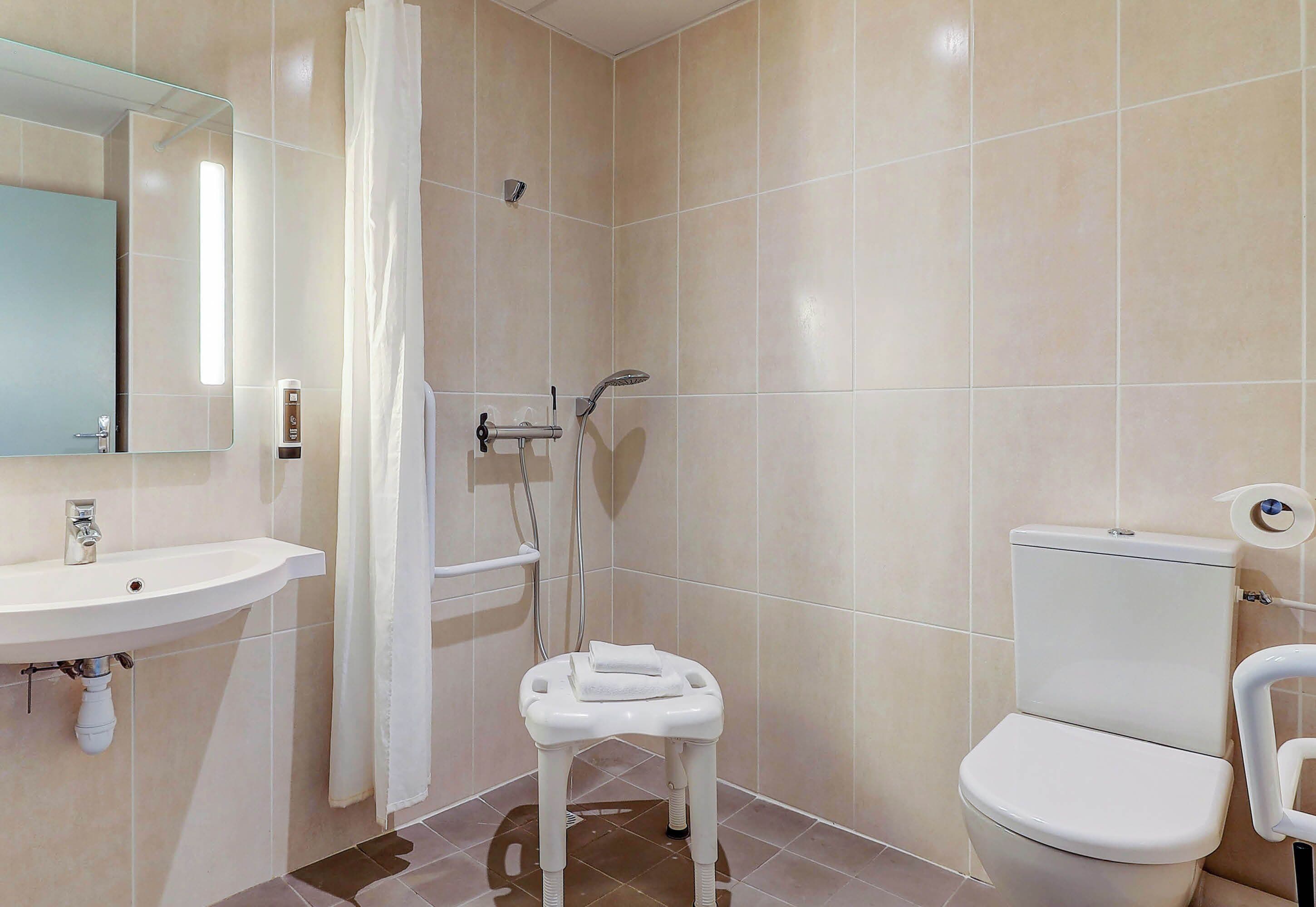 A bathroom with a sink, toilet, and shower area.
