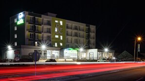 Un hotel de varios pisos con un llamativo letrero que dice 'HOTEL', múltiples balcones y una fachada bien iluminada.