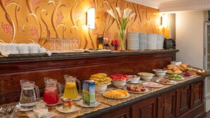 A buffet counter with various food items, beverages, and condiments. - Little Diamond Hotel (Hanoi)