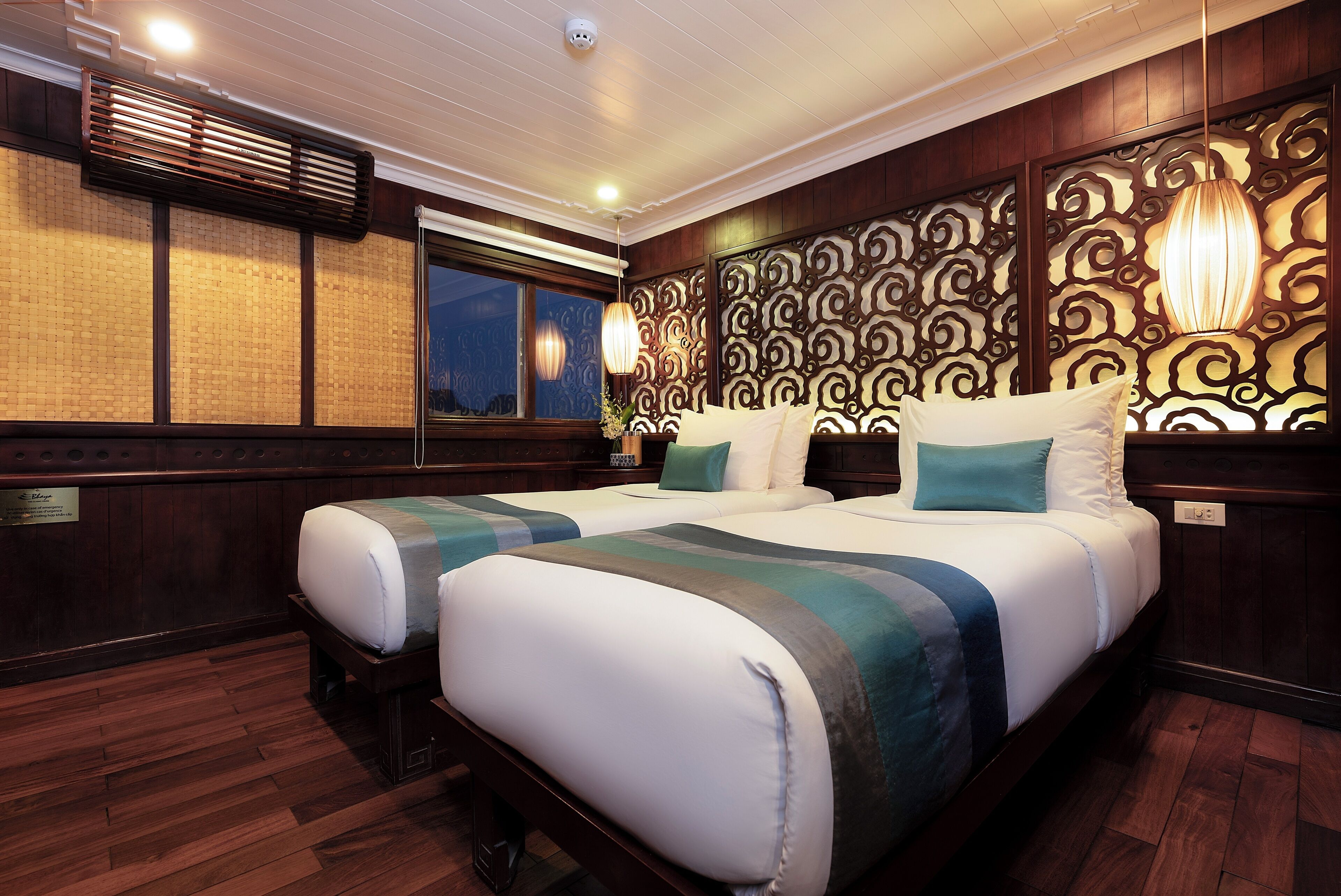 A hotel room with a large bed, wooden paneling, a decorative wall, and a window.