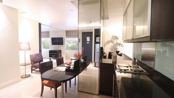 A modern kitchen with a dining area, a flat-screen TV, and a view of the city.