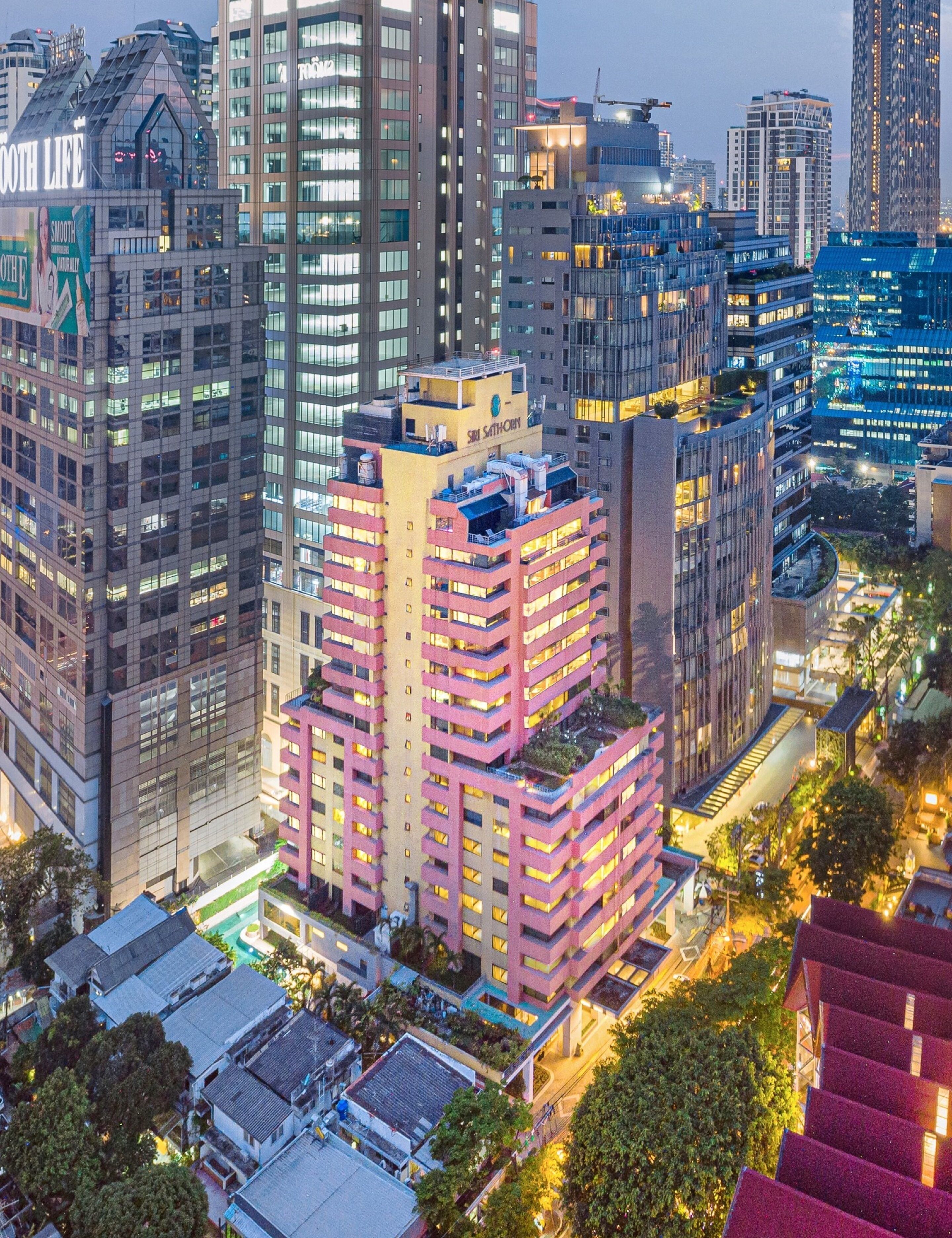 A high-rise building with multiple floors, large windows, and a prominent sign on the top.