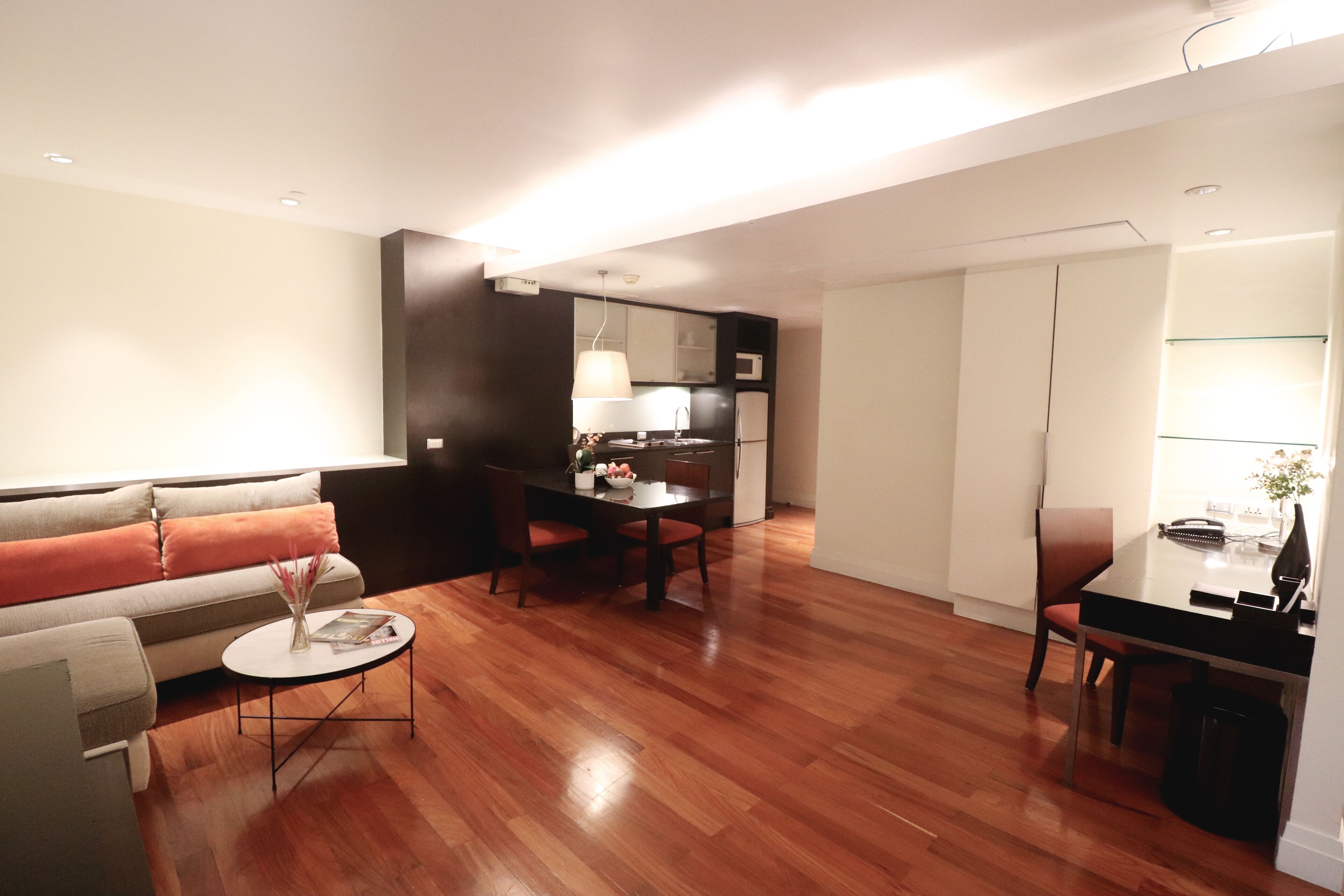A modern living room with a sofa, coffee table, and dining area.