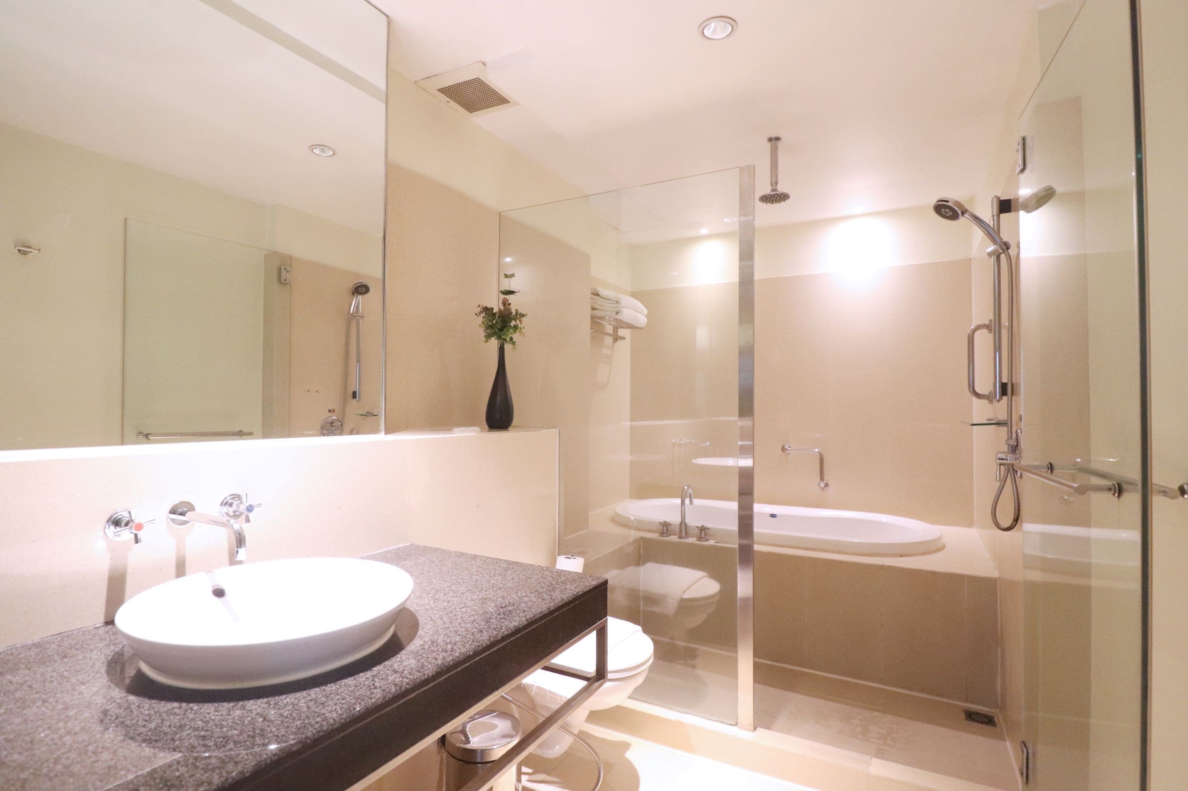 A modern bathroom with a glass-enclosed shower, a standalone bathtub, and a vanity with a sink.