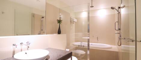 A modern bathroom with a glass-enclosed shower, a standalone bathtub, and a vanity with a sink.