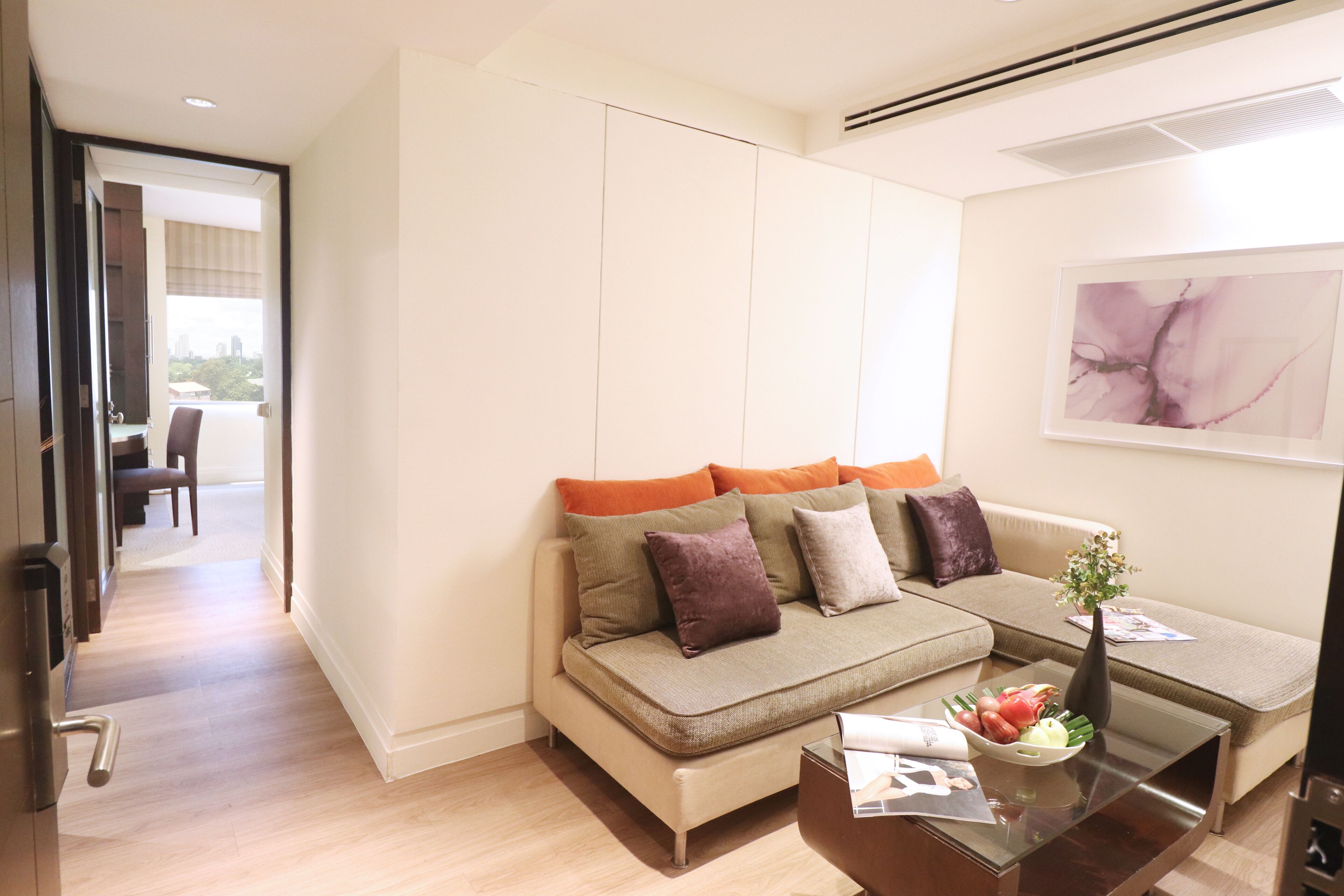Una sala de estar moderna con un sofá, una mesa de centro y un cuadro en la pared.