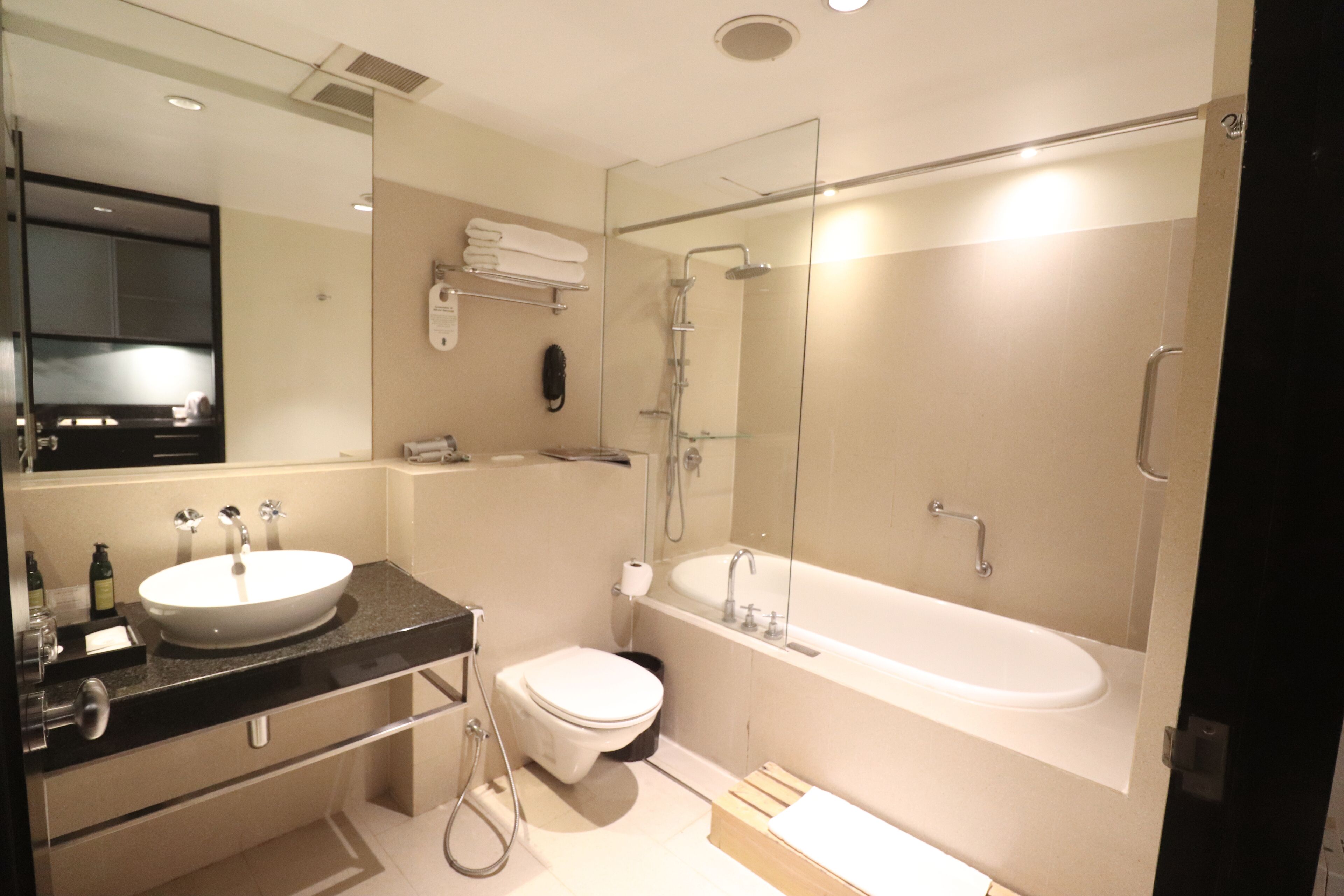 A modern bathroom with a large sink, toilet, and bathtub.