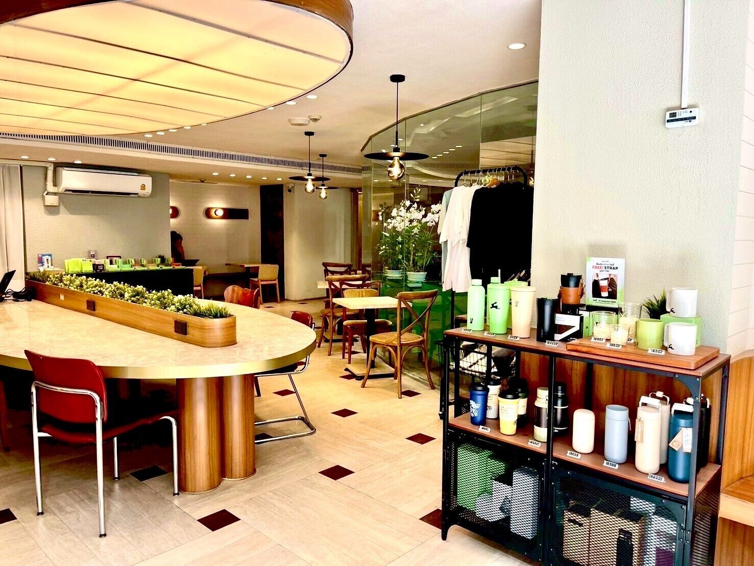 A modern hotel lobby with a central seating area, a reception desk, and a display of amenities.