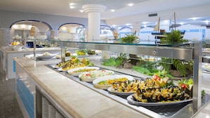 A buffet with various dishes, including seafood, arranged on a counter with a glass barrier. - Club Hotel Marina Beach (Orosei)