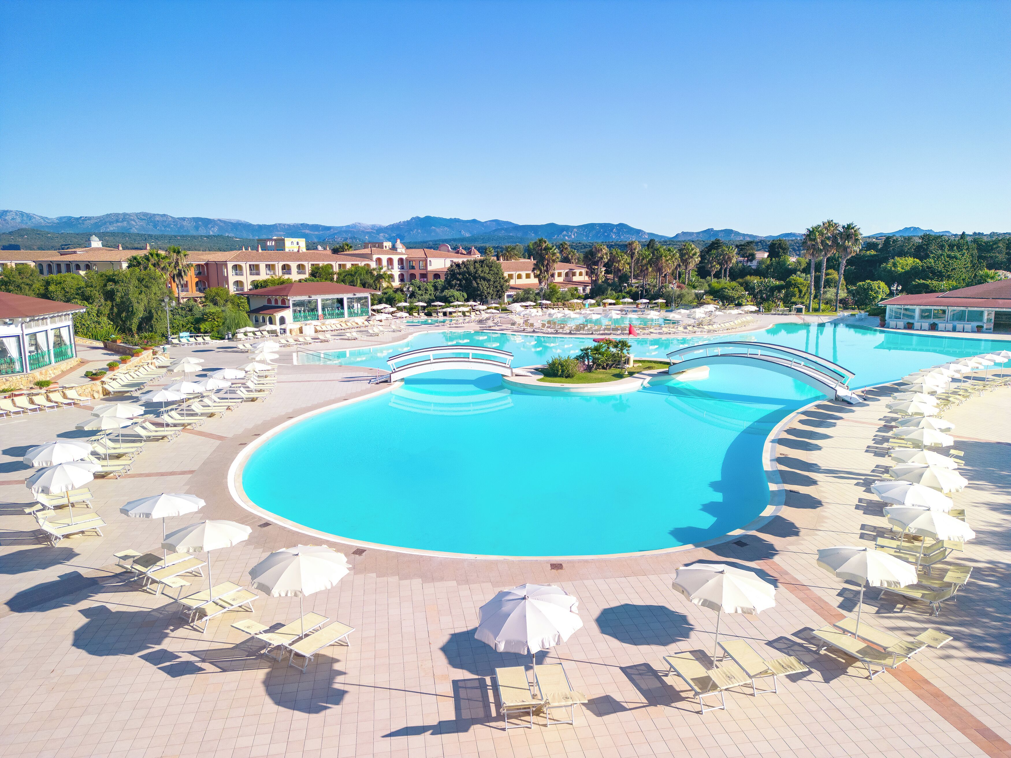 Et resort med flere swimmingpools, liggestole og parasoller.
