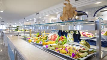 Un buffet proposant une variété de plats et agrémenté d’une maquette de bateau décorative.
