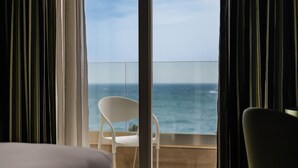 A hotel room with a balcony overlooking the sea.