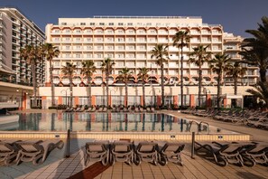 A hotel with a large pool, sun loungers, and palm trees. - QAWRA Palace Resort & SPA (St. Paul's Bay)