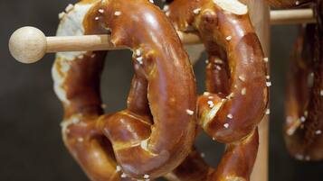A pretzel on a wooden hook with visible salt crystals.