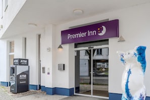 A Premier Inn entrance with an ATM machine, a glass door, and a blue and white sculpture. - Premier Inn Berlin City Spittelmarkt (Berlin)