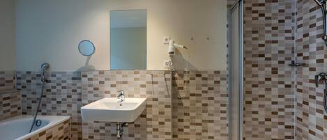 A bathroom with a bathtub, a sink, a shower, and a glass-enclosed shower stall.
