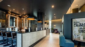A modern bar area with a counter, multiple mirrors, and bar stools.