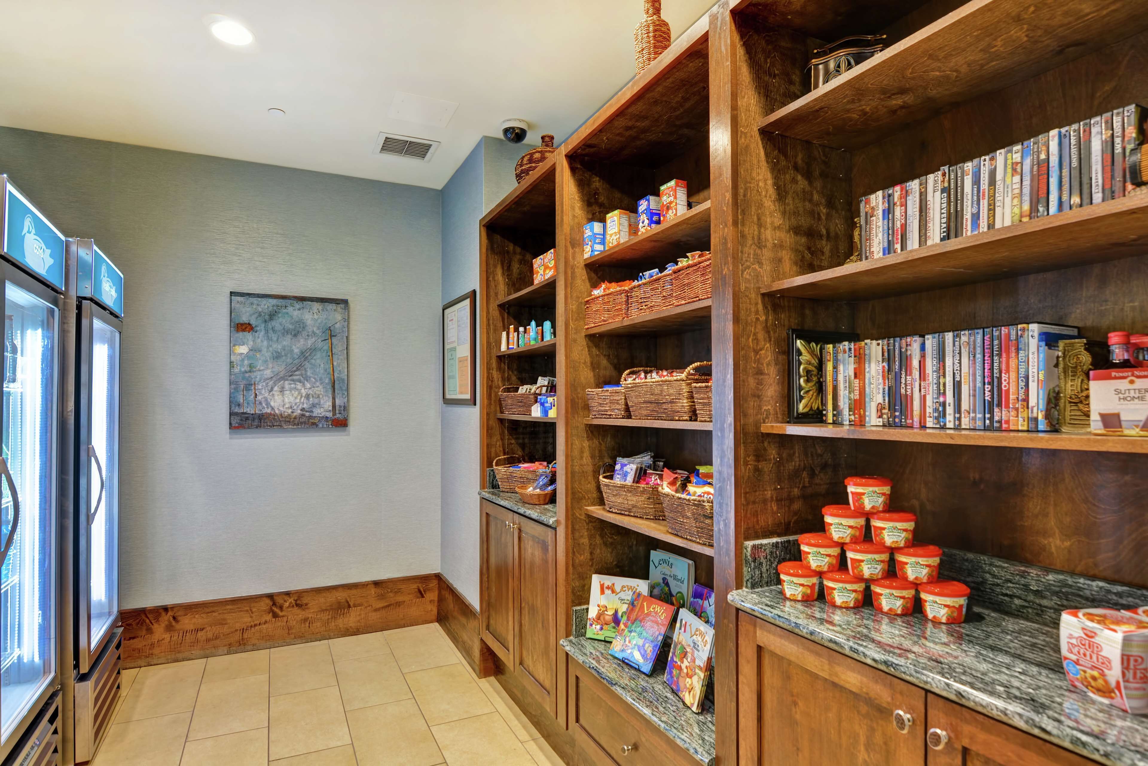 A kitchen with wooden shelves stocked with books, baskets, and kitchen items.