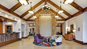 A lobby with a reception desk, seating area, and a stone accent wall.