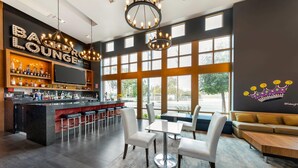 A bar/lounge area with a bar counter, seating, and large windows. - BLVD Hotel and Studios Universal-Hollywood, an Ascend Collection Hotel (Studio City)