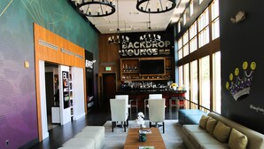 A spacious lobby with a bar area, seating, and a large wall with a sign reading "BACKDROP LOUNGE EST. 2011". - BLVD Hotel and Studios Universal-Hollywood, an Ascend Collection Hotel (Studio City)
