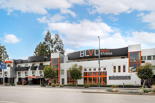 A hotel with a modern design, featuring a prominent 'BLVD HOTELS' sign, multiple balconies, and a landscaped front yard. - BLVD Hotel and Studios Universal-Hollywood, an Ascend Collection Hotel (Studio City)