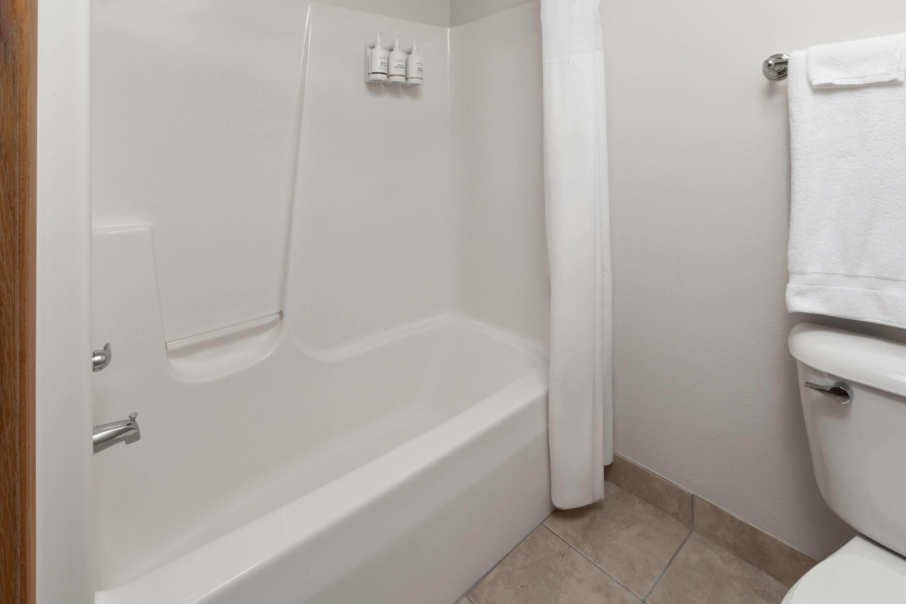 Ein Badezimmer mit einer weißen Badewanne, einer Toilette und einer Duschvorhang.