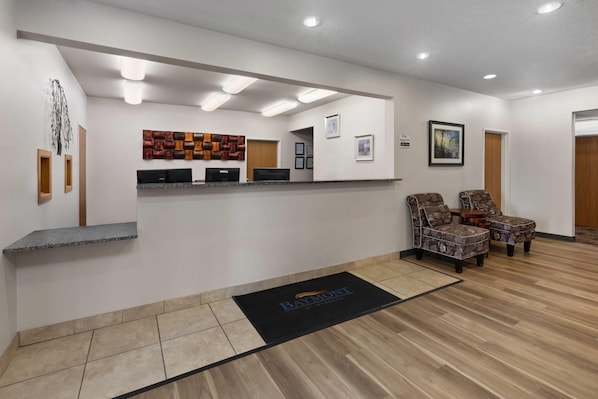 A reception area with a desk, computers, and seating.