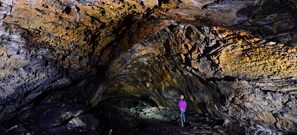 A person standing in a cave with rough, uneven walls and a narrow passageway. - Holiday Inn Express & Suites Klamath Falls Central by IHG (Klamath Falls)