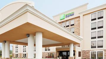 A Holiday Inn Express hotel with a covered entrance, stone facade, and multiple windows.