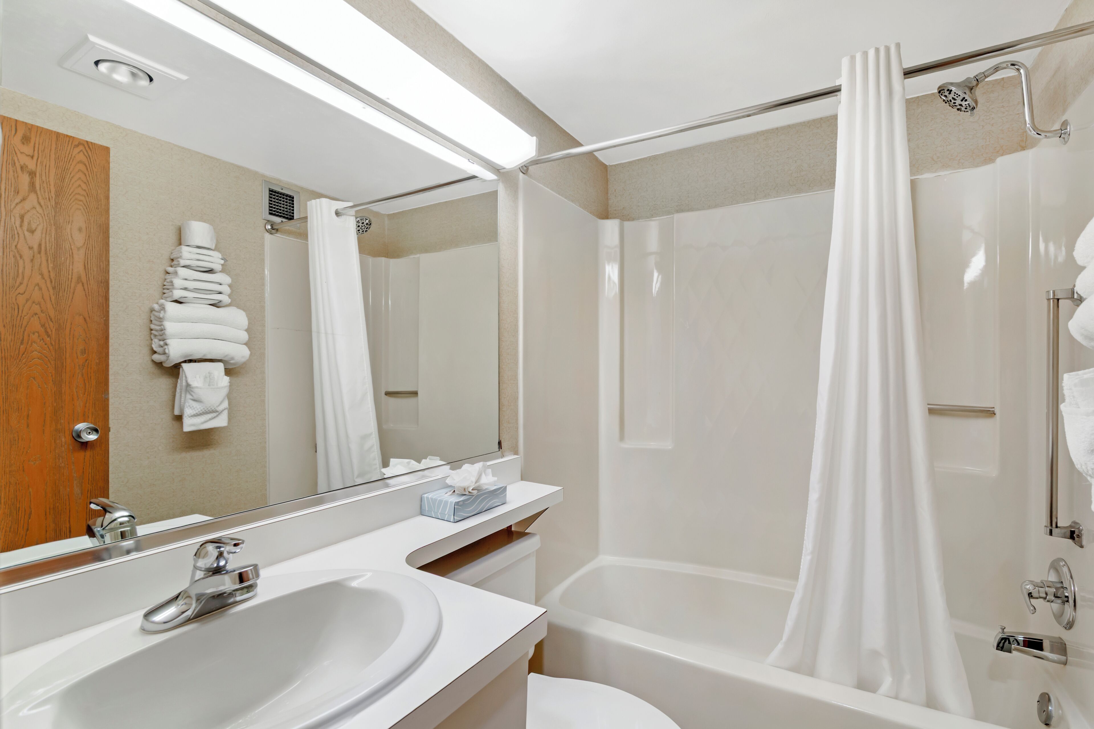 A modern bathroom with a sink, mirror, and shower.