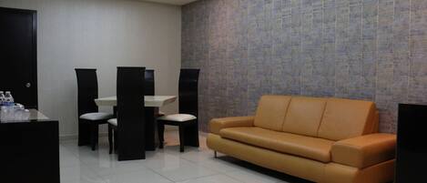 A modern lobby with a sofa, a reception desk, and a wall with a textured pattern.