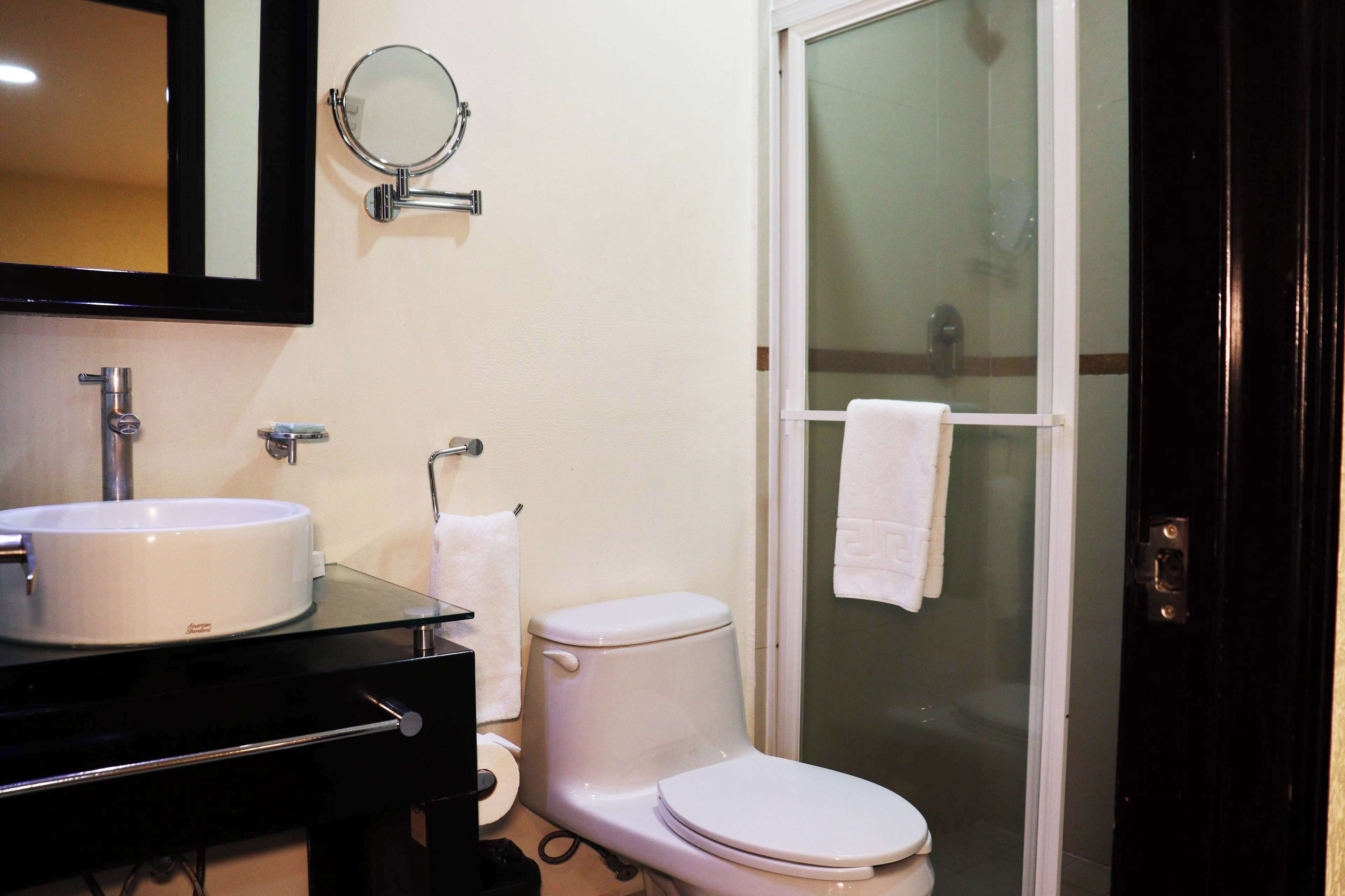 A bathroom with a sink, toilet, and a glass shower enclosure.