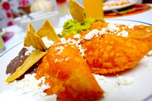 A plate of food with nachos, guacamole, and cheese. - Hotel Spa Taninul (Tamuín)