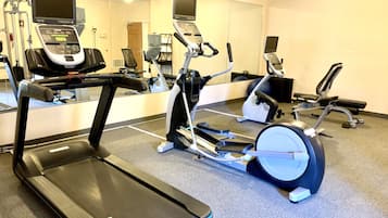 A gym with a treadmill, elliptical, and stationary bike.