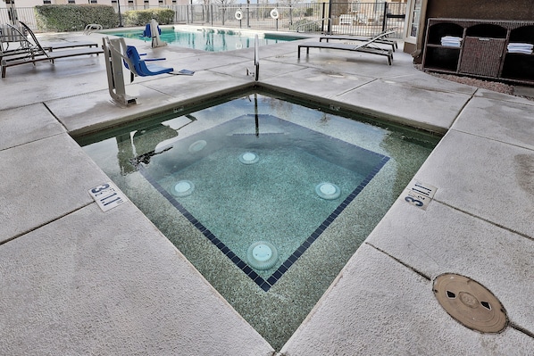 Une piscine avec une zone à eau claire, un plongeoir et des chaises longues.