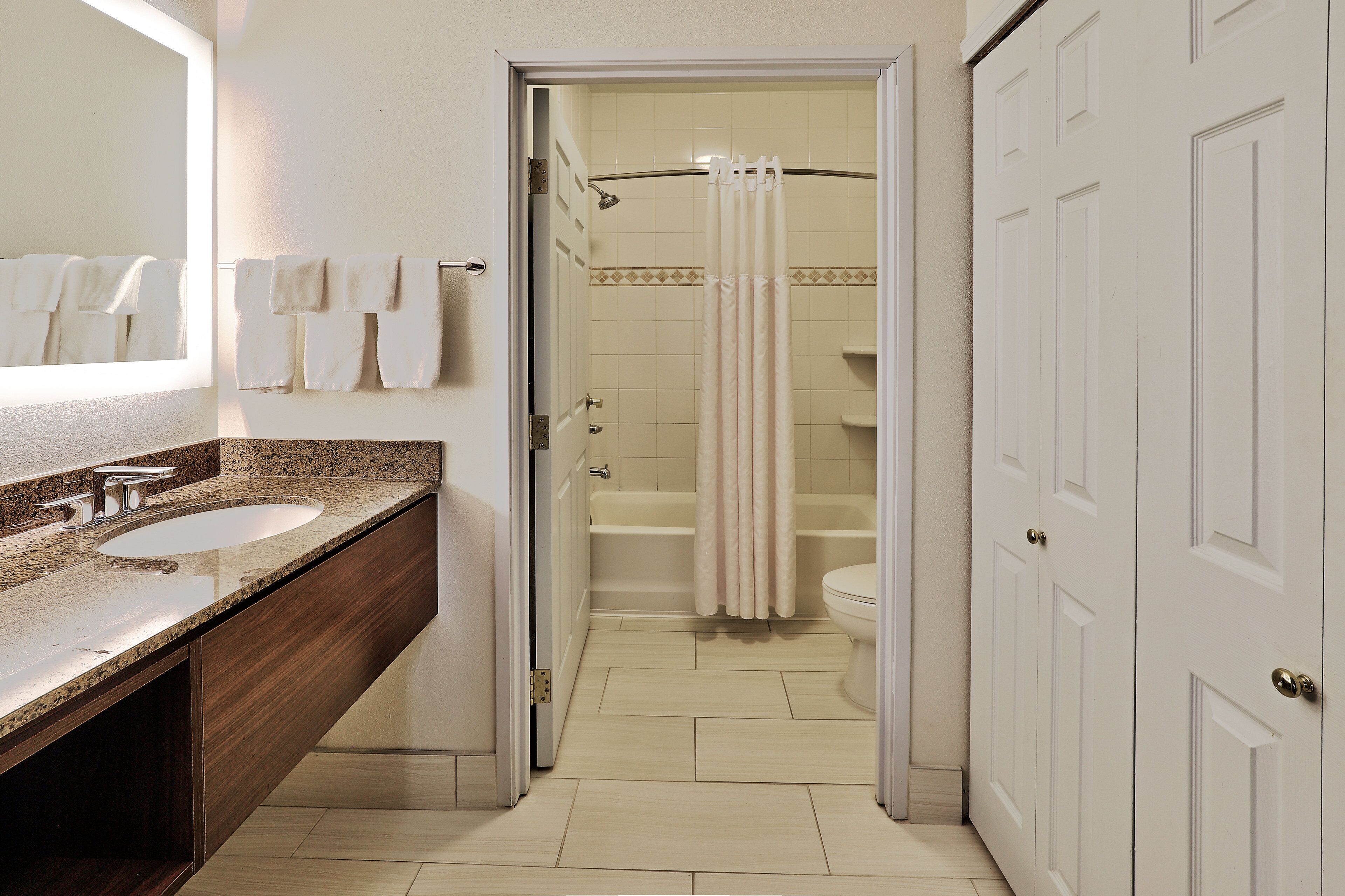 Une salle de bain avec deux lavabos, une douche avec un rideau et des toilettes.