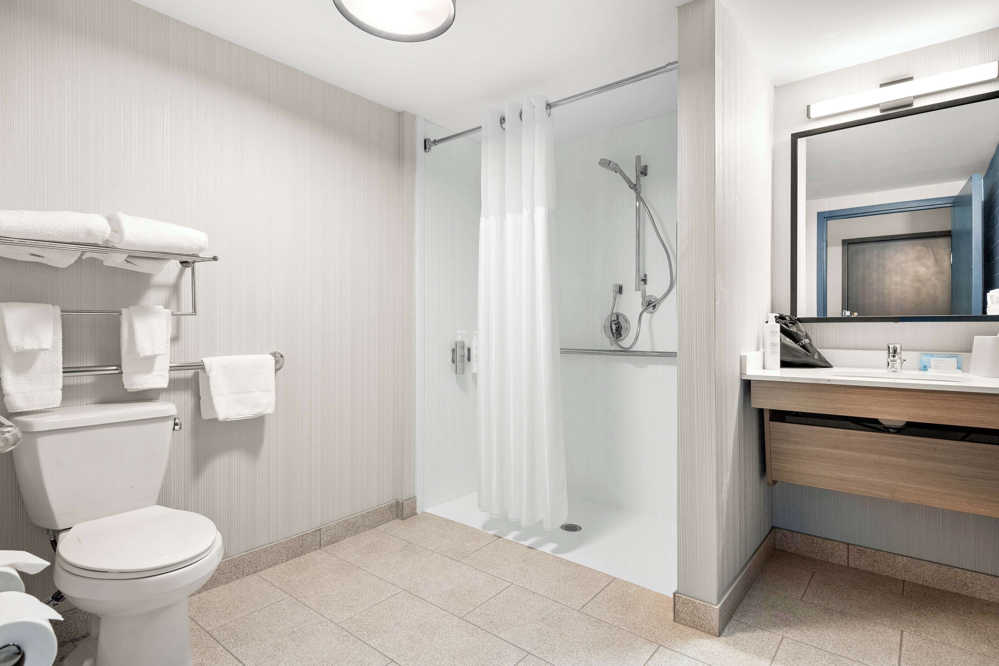 Un baño moderno con inodoro, ducha y lavabo.