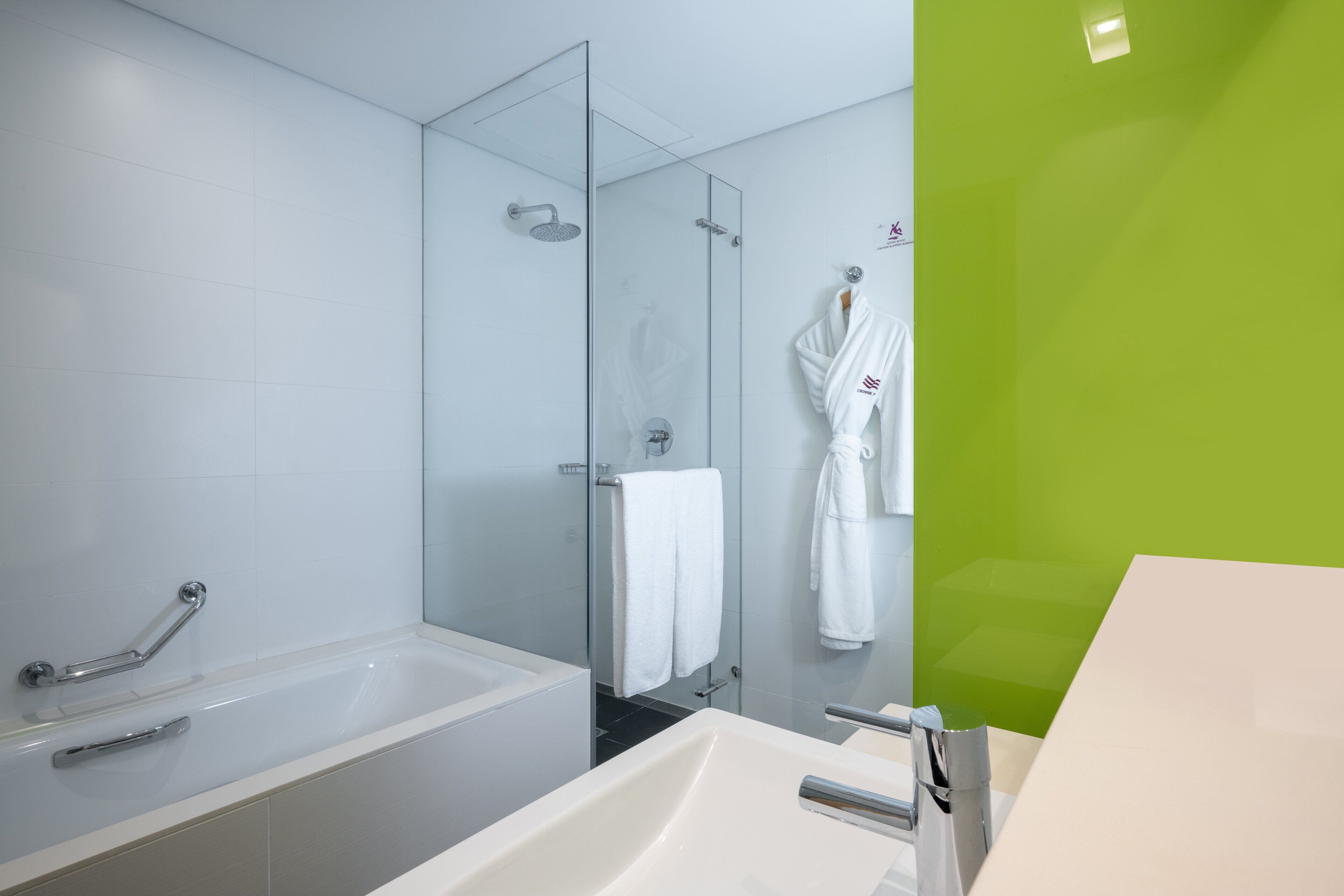 A modern bathroom with a bathtub, a shower, and a sink.